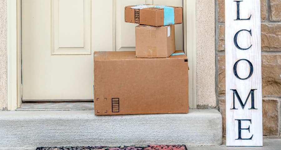 Packages on the doorstep of a home with a welcome sign in Pensacola